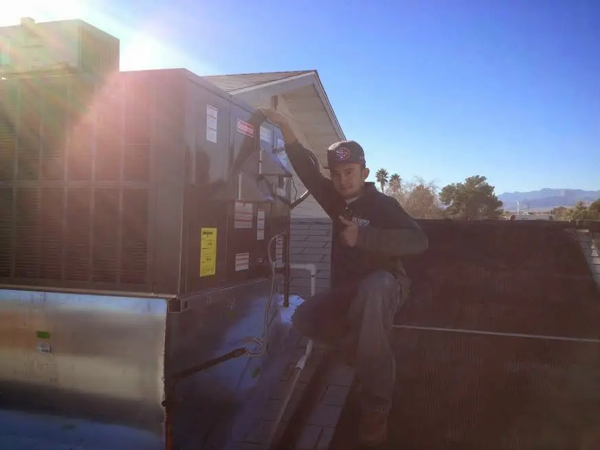 HVAC technician performing HVAC Inspection on a rooftop unit in Volo